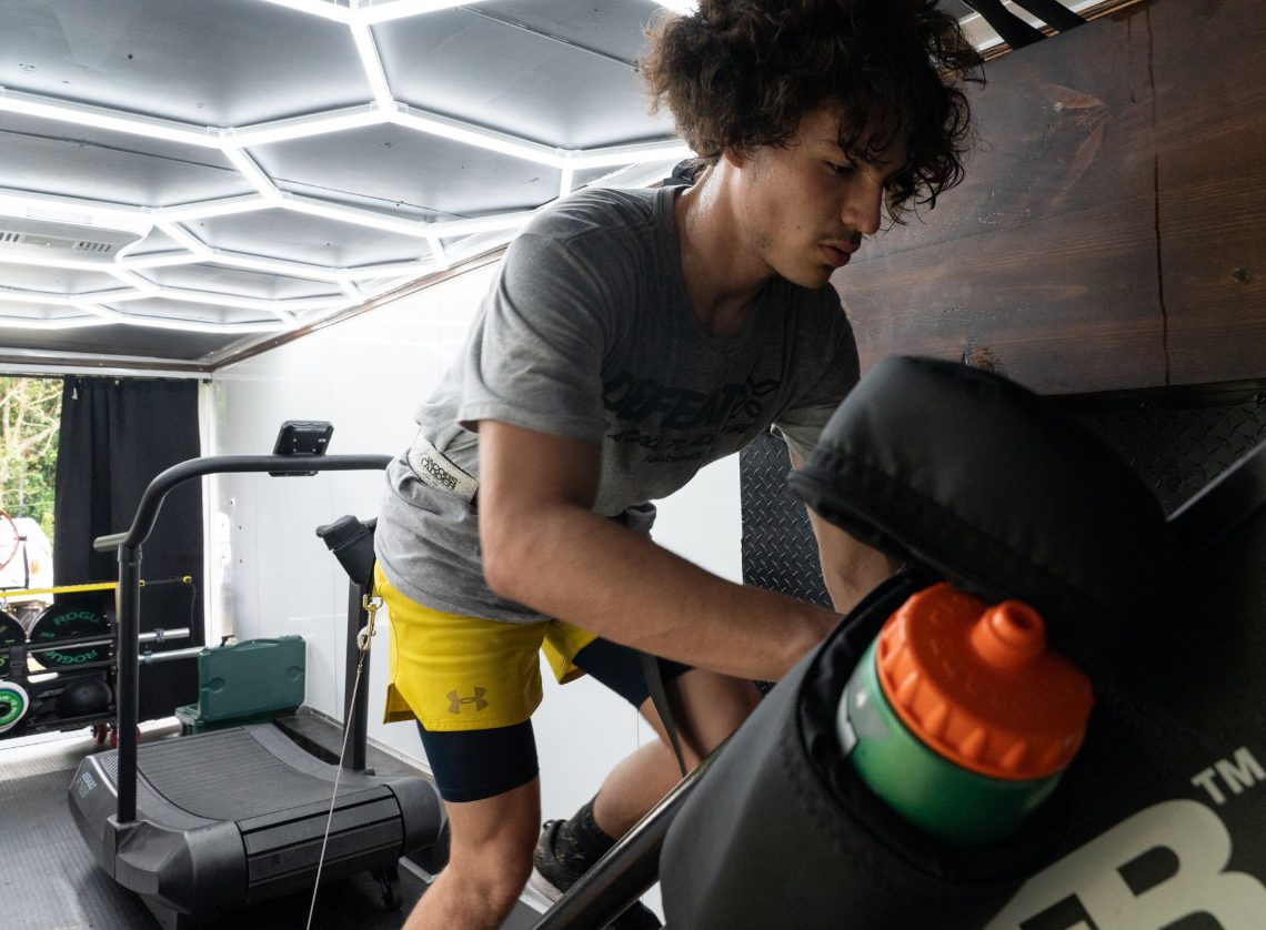 A client climbing the Jacob's Ladder inside the Defeat X training rig